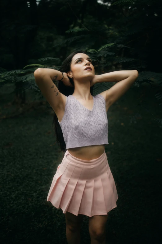 a woman standing in a field with her arms behind her head, a colorized photo, inspired by Elsa Bleda, pexels contest winner, renaissance, pink tight mini-skirt, wearing a tanktop and skirt, woman with black hair, wearing casual clothing