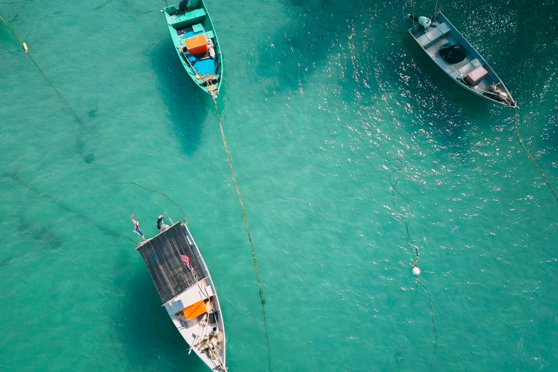 a group of boats floating on top of a body of water, a screenshot, pexels contest winner, teal, fishing, aruba, conde nast traveler photo