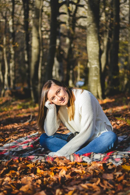 a woman sitting on a blanket in the woods, a portrait, pexels contest winner, 15081959 21121991 01012000 4k, wearing a white sweater, college, avatar image
