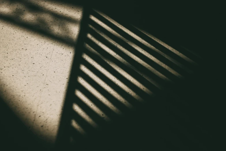 a black and white photo of a shadow of a chair, inspired by Elsa Bleda, unsplash, soft light through blinds, square lines, deep shadows and colors, ( ( ( in a dark