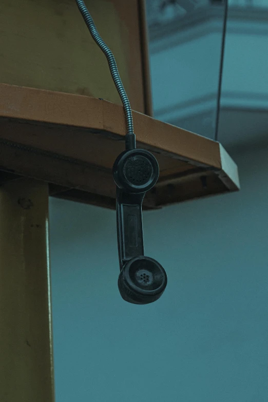 a close up of a telephone on a pole, by Attila Meszlenyi, witness stand, digital image, headset, black