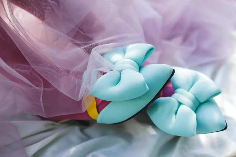 a pair of blue shoes sitting on top of a bed, inspired by Jeff Koons, pexels contest winner, wearing hair bow, candy pastel, closeup - view, soft pads
