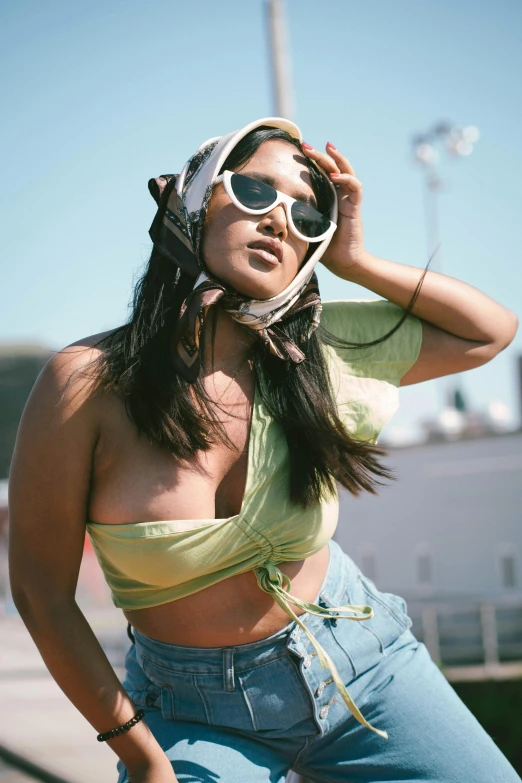 a beautiful young woman sitting on top of a skateboard, inspired by Ren Hang, trending on pexels, green halter top, big sunglasses, lizzo, provocative indian