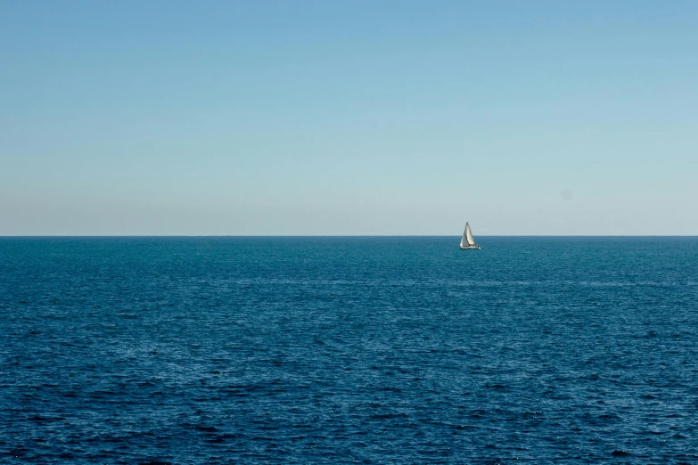 a sailboat in the middle of a large body of water, unsplash, minimalism, crossing the blue horizon, ignant, slightly pixelated, distant full body view