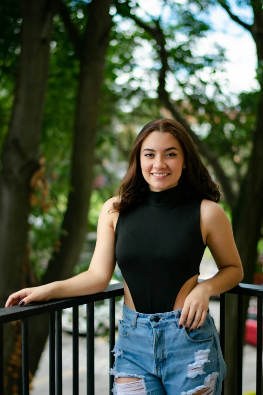 a beautiful young woman standing on top of a balcony, a portrait, pexels contest winner, renaissance, wearing a cropped black tank top, portrait sophie mudd, trees in background, alexandria ocasio cortez