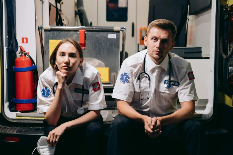 two parameds sitting in the back of an ambulance, a portrait, by Adam Marczyński, pexels contest winner, hyperrealism, wearing rr diner uniform, sitting on a lab table, sydney hanson, charlie bowater and mark brooks