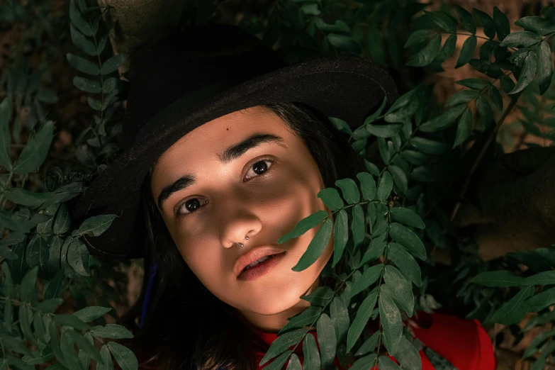 a close up of a person wearing a hat, an album cover, by Julia Pishtar, pexels contest winner, covered in vines, ana de la reguera portrait, portrait androgynous girl, portrait of mulan