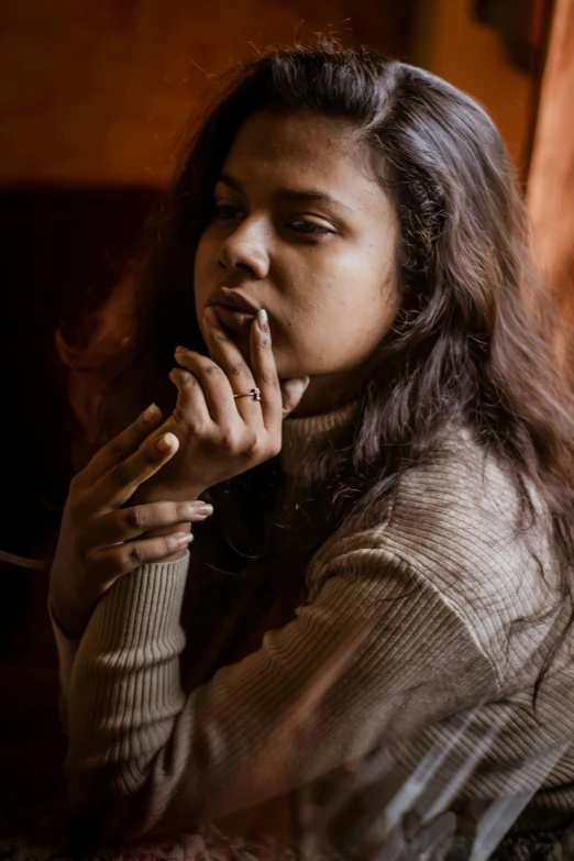 a woman sitting on a couch smoking a cigarette, a portrait, inspired by Elsa Bleda, pexels contest winner, renaissance, indian girl with brown skin, sitting in a cafe, windy mood, ((portrait))