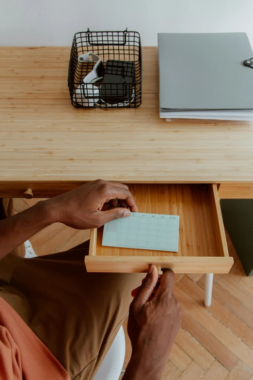 a man sitting at a desk in front of a laptop, pexels contest winner, sustainable materials, hidden message, square, bamboo wood