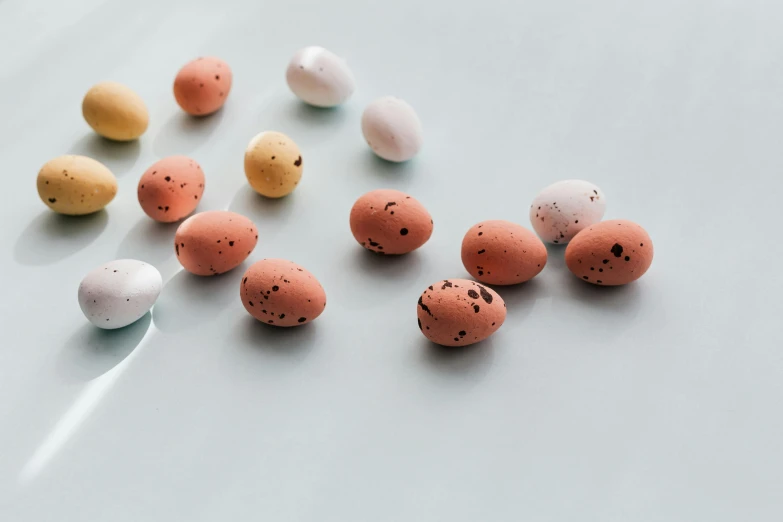 a bunch of eggs sitting on top of a table, by Ellen Gallagher, trending on unsplash, jellybeans, varying dots, seeds, miniature product photo