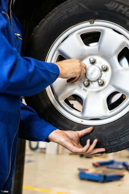 a mechanic working on a tire in a garage, alliance, superior detail, thumbnail, impressive detail : 7