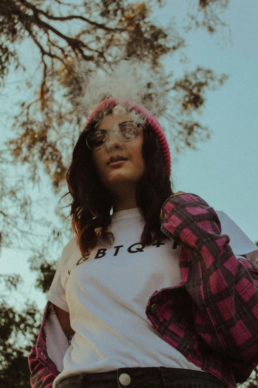 a woman standing in front of a tree smoking a cigarette, trending on pexels, kitsch movement, she is wearing streetwear, bust shot, lumberjack, bisexual lighting