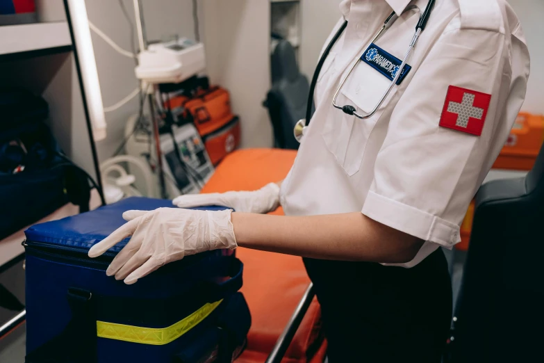 a woman in a white uniform holding a blue suitcase, pexels, happening, ambulance, surgery theatre, wearing gloves, avatar image