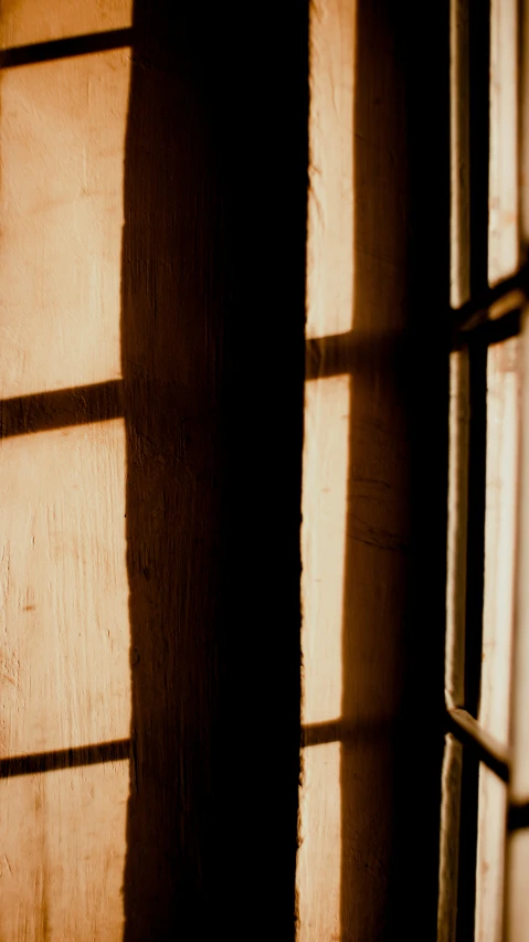 a close up of a window with light coming through it, an album cover, inspired by William Nicholson, pexels, brown, golden light film grain, a wooden, shadowy