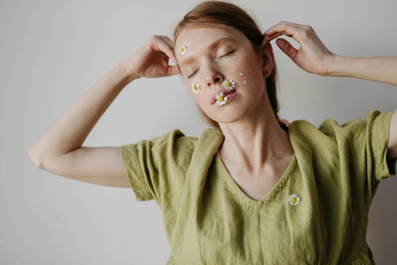 a woman with food all over her face, by Emma Andijewska, trending on pexels, chamomile, green and brown clothes, falling petals, sleepy