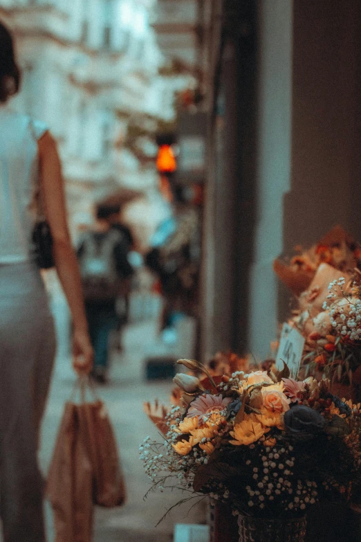 a woman walking down a street past a bunch of flowers, pexels contest winner, romanticism, people shopping, golden glow, brown, standing elegantly