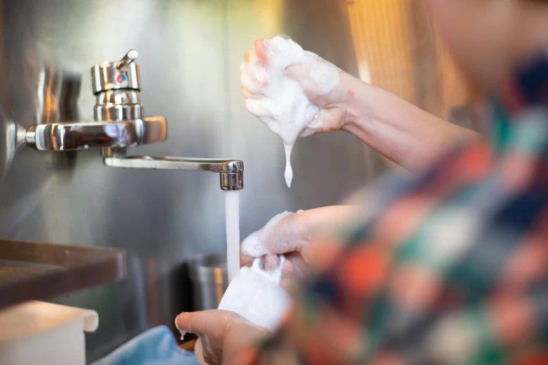 a person washing their hands under a faucet, pexels, process art, dry ice, customers, holding a milkor mgl, lightly dressed
