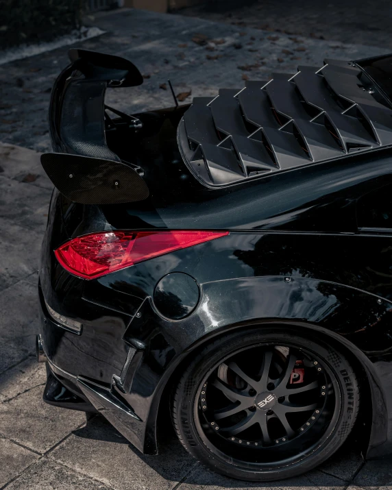 a black sports car parked on the side of the road, by Adam Marczyński, pexels contest winner, sharp irregular spiraling wings, tail lights, full body close-up shot, 15081959 21121991 01012000 4k