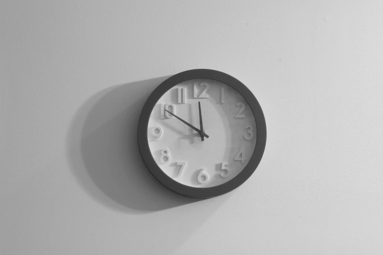 a black and white photo of a clock on a wall, an ambient occlusion render, pexels, minimalism, white plastic, taken in the late 2000s, a high angle shot, white background wall