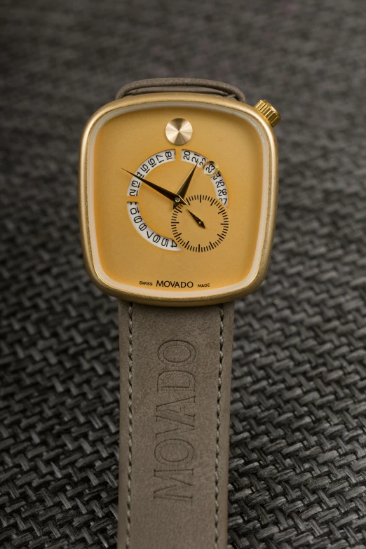 a close up of a watch on a table, inspired by Kanō Tan'yū, the madness of mono-yellow, shades of gold display naturally, nomad, square