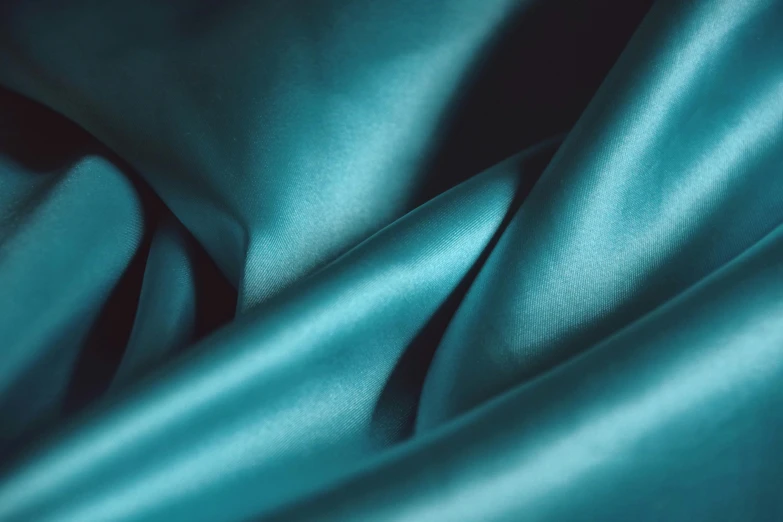 a close up of a blue satin fabric, inspired by Elsa Bleda, trending on unsplash, teal lighting, jade green, features, cyan