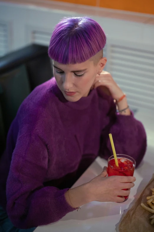 a woman with purple hair sitting at a table, 🍸🍋, non binary model, profile image, purple clothes