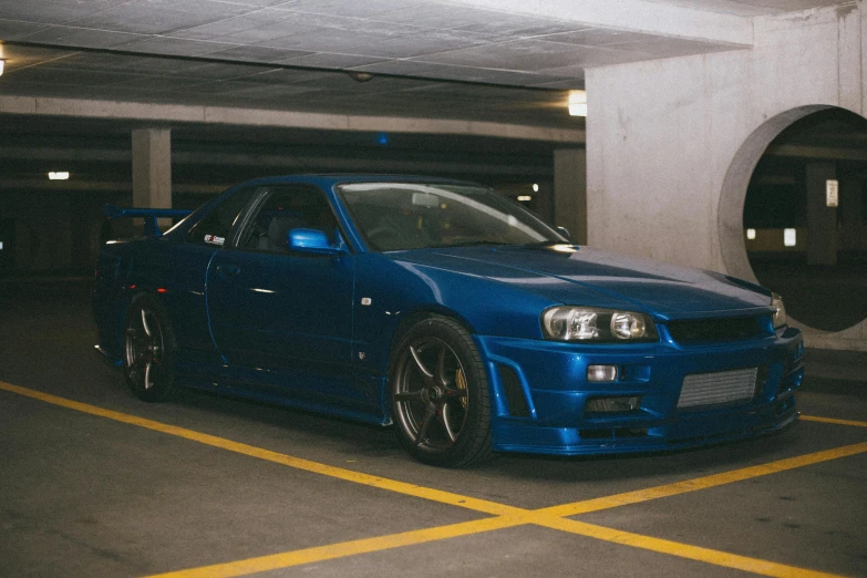 a blue car parked in a parking garage, by Nōami, pexels contest winner, in a modified nissan skyline r34, avatar image, garage kit, sports car in the room