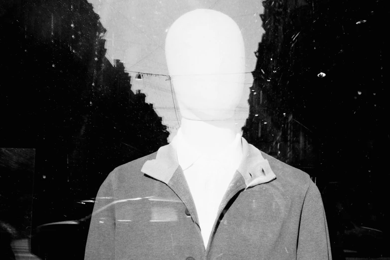 a black and white photo of a mannequin, an album cover, by Jan Rustem, unsplash, surrealism, wearing a turtleneck and jacket, white mask, he has an elongated head shape, no faces visible