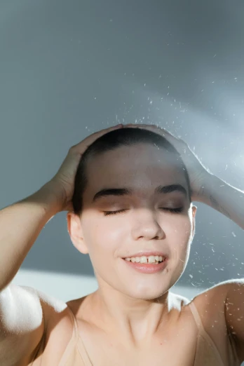 a woman washing her hair in a bathtub, trending on pexels, light over boy, halo above head, sweating, non binary model