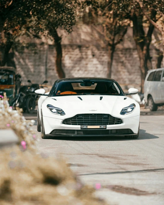 a white sports car parked on the side of the road, inspired by Harry Haenigsen, unsplash contest winner, tehran, aston martin, instagram photo, ::