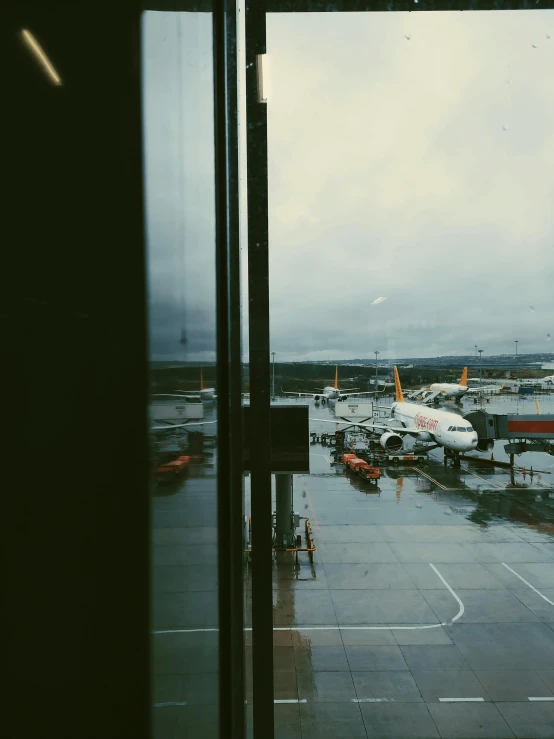 a large jetliner sitting on top of an airport tarmac, a polaroid photo, inspired by Thomas Struth, pexels contest winner, raining outside the window, trending on vsco, helsinki, low quality footage