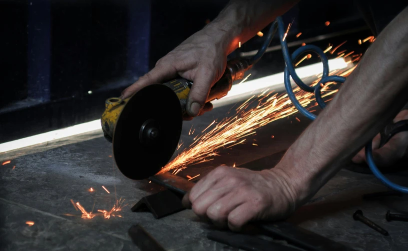 a man using a grinder on a piece of metal, by Dave Allsop, pexels contest winner, ultrarealistic, iron cladding, thumbnail, multiple stories