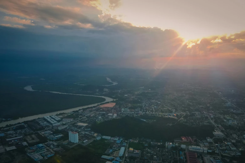 an aerial view of a city at sunset, a picture, pexels contest winner, sumatraism, sun after a storm, view from helicopter, sunlight reflected on the river, rectangle