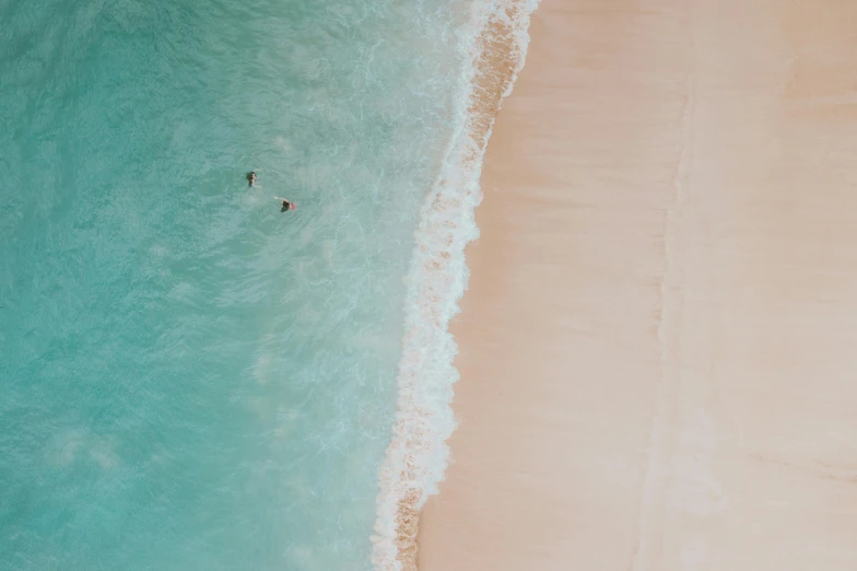 a couple of people laying on top of a sandy beach, pexels contest winner, minimalism, swimming through the ocean, refreshing colour, birds eye, hawaii