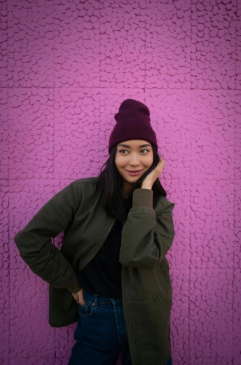 a woman standing in front of a purple wall talking on a cell phone, pexels contest winner, black beanie, portrait of mulan, instagram picture, wearing jacket