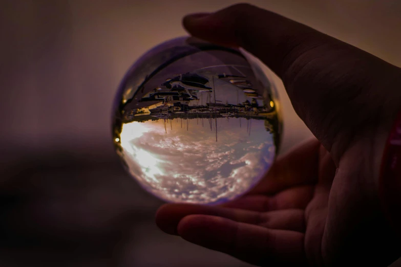 a person holding a crystal ball in their hand, a picture, inspired by Beeple, pexels contest winner, marble!! (eos 5ds r, refracted sunset lighting, high angle shot, profile pic