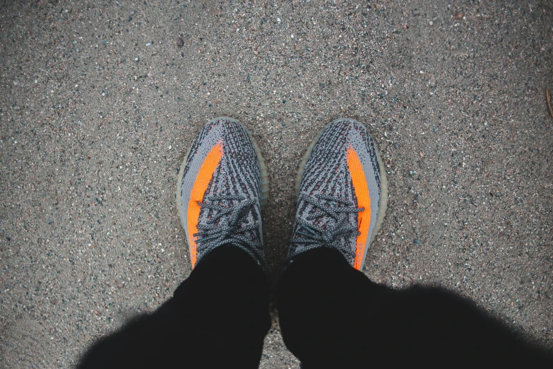 a person's feet in a pair of running shoes, pexels contest winner, yeezus, orange and black, avatar image, full body pov