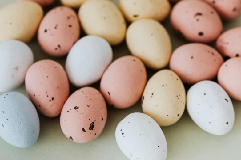 a pile of eggs sitting on top of a table, by Emma Andijewska, trending on unsplash, candy decorations, background image, 2045, close-up photo