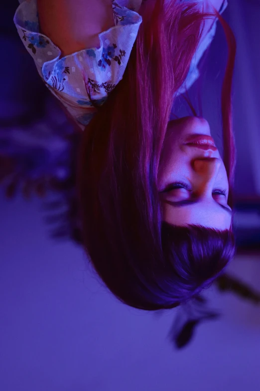 a woman laying on top of a bed next to a laptop computer, inspired by Elsa Bleda, trending on pexels, magical realism, blue and purple glowing hair, hanging from the ceiling, close up head shot, red hue