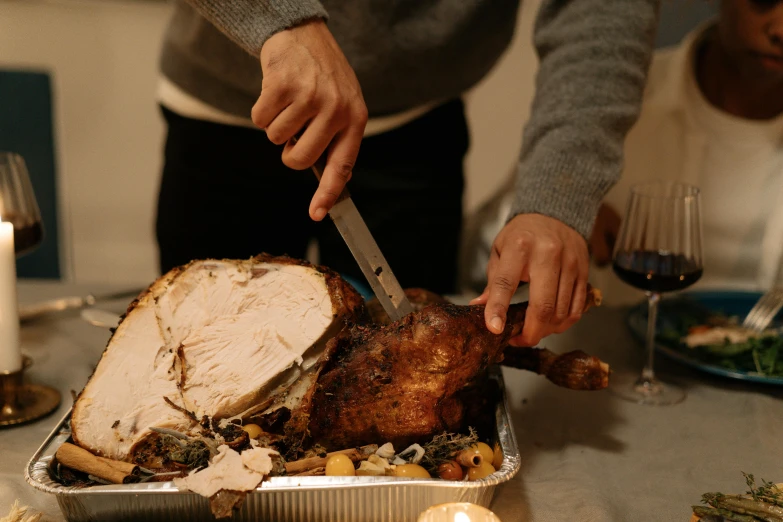 a person cutting a turkey with a knife, by Carey Morris, pexels contest winner, australian, uplit, rectangle, cast