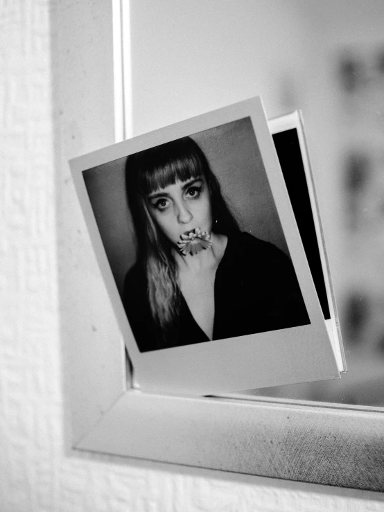 a black and white photo of a woman in front of a mirror, a polaroid photo, by Lucia Peka, pexels contest winner, pop art, with fangs, grimes - book 1 album cover, square pictureframes, window