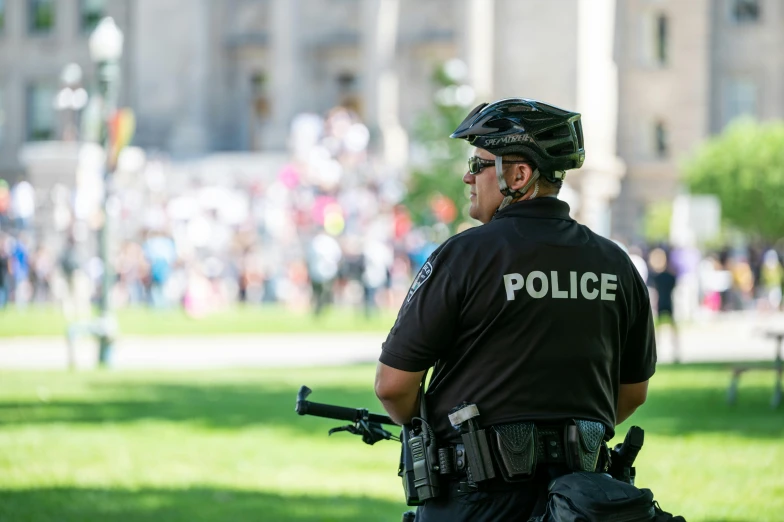 a police officer standing in front of a crowd of people, college, profile image, wearing tactical gear, 🚿🗝📝