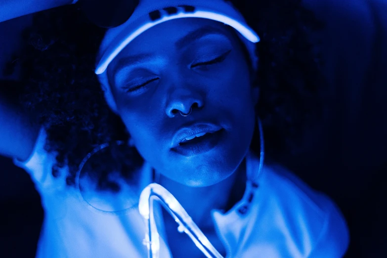 a close up of a person with a tennis racket, by Adam Marczyński, pexels contest winner, afrofuturism, glowing blue, listening to music at 2 am, tessa thompson inspired, white neon