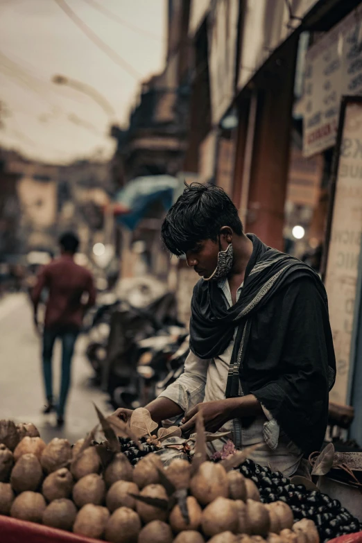 a man standing next to a pile of potatoes, pexels contest winner, renaissance, on an indian street, busy cityscape, thumbnail, man wearing a closed cowl