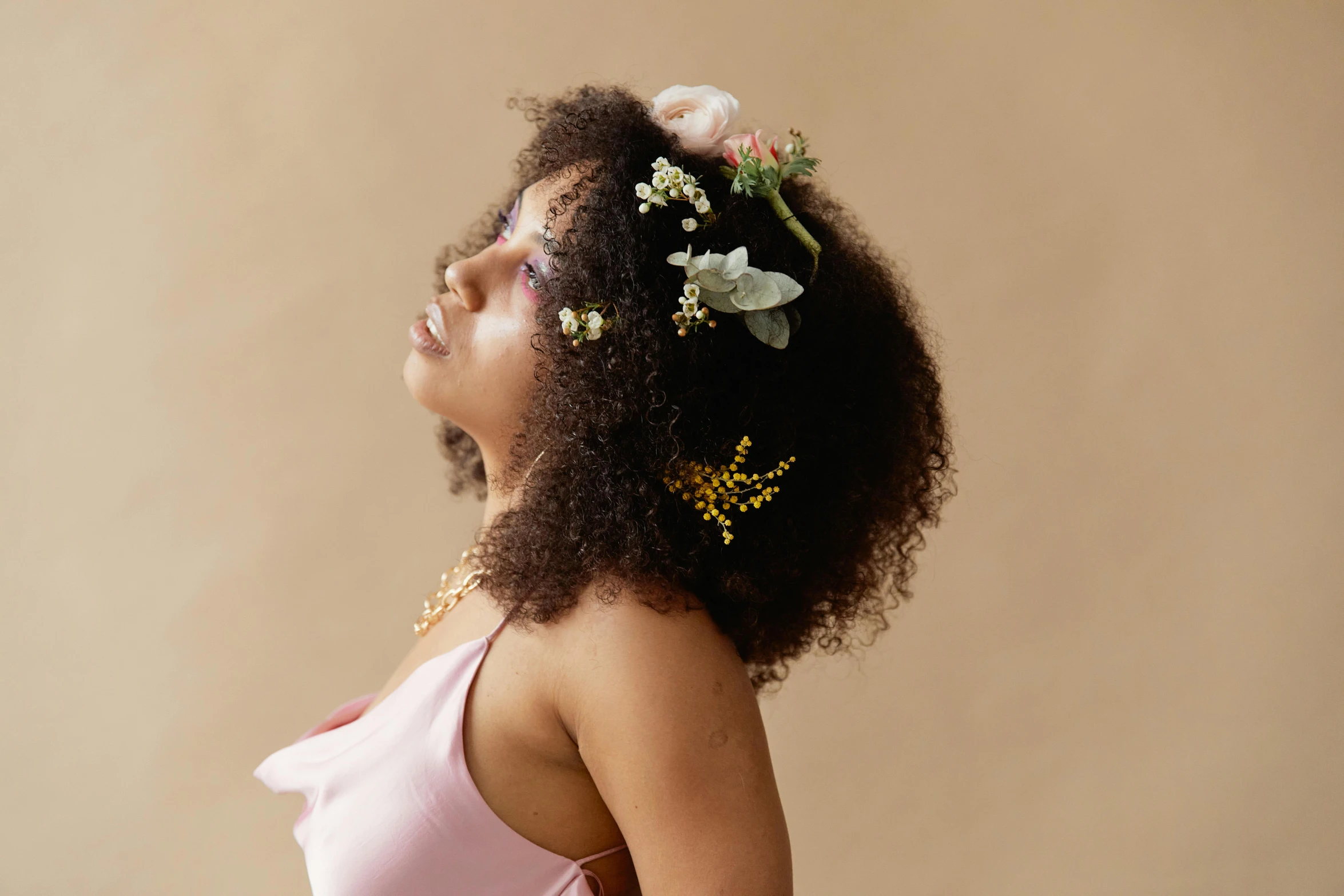 a woman with a flower in her hair, an album cover, trending on pexels, curls and curves, various posed, mixed-race woman, pastel'