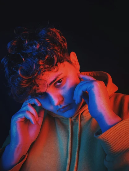 a close up of a person talking on a cell phone, an album cover, inspired by John Luke, trending on pexels, realism, bisexual lighting, thoughtful pose, roygbiv, curly and short top hair