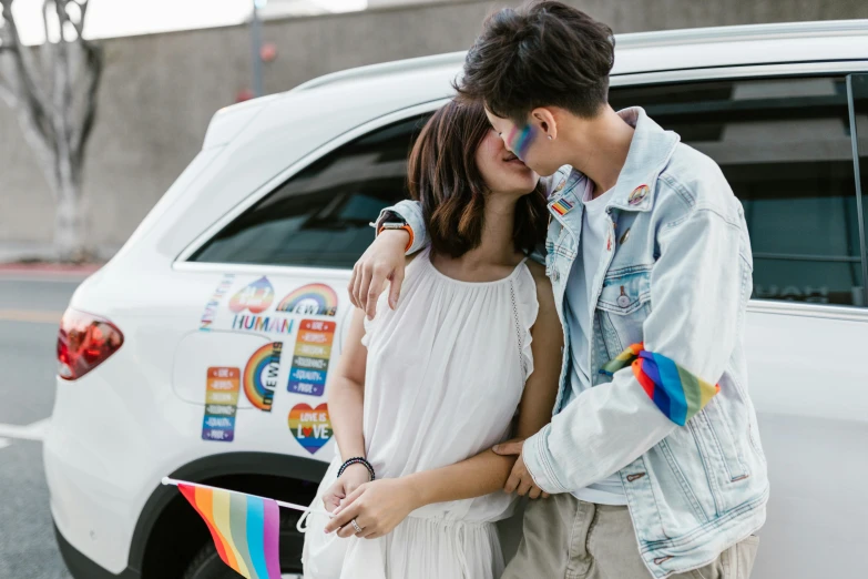 a man and woman kissing in front of a car, a photo, by Okuda Gensō, trending on pexels, renaissance, cai xukun, rainbow accents, ta ha