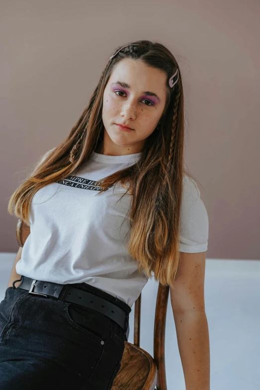 a woman sitting on top of a wooden chair, an album cover, inspired by Hannah Frank, trending on pexels, violet coloured t-shirt, portrait sophie mudd, in white room, lovingly looking at camera