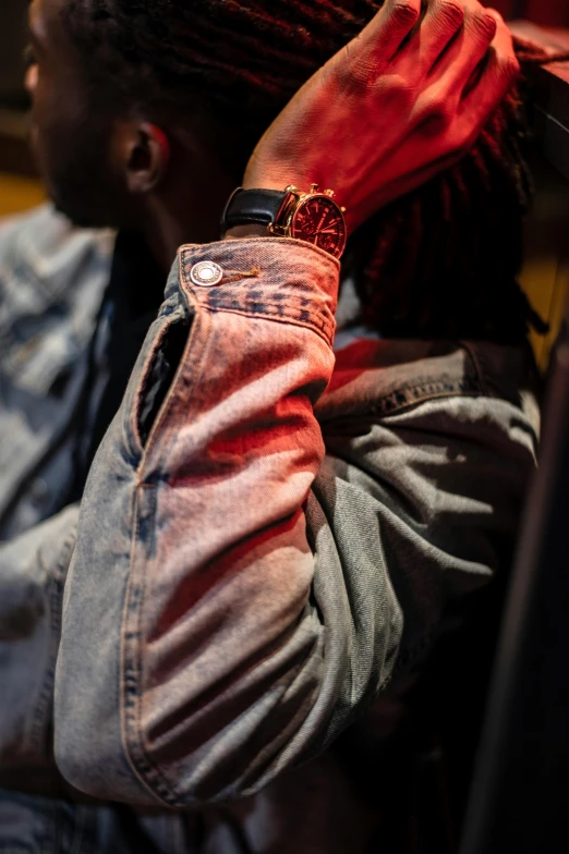 a man with dreadlocks sitting on a bus, an album cover, trending on pexels, denim jacket, detailed red lighting, close up shot from the side, holding arms on holsters