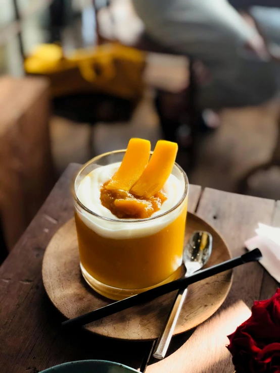 a drink sitting on top of a wooden table, inspired by Max Buri, unsplash, mango, yogurt, sichuan, pastry